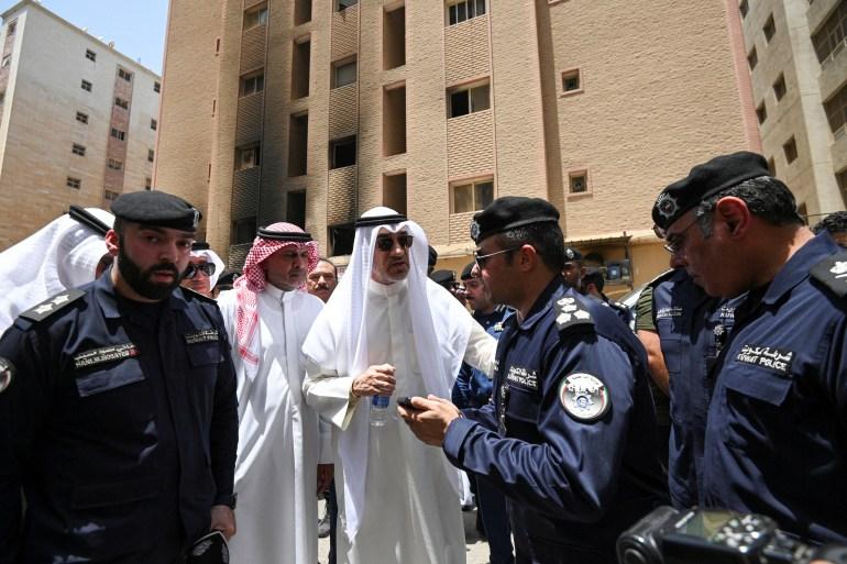 Deputy Prime Minister Sheikh Fahad al-Yousuf al-Sabah speaks with police officers at the site