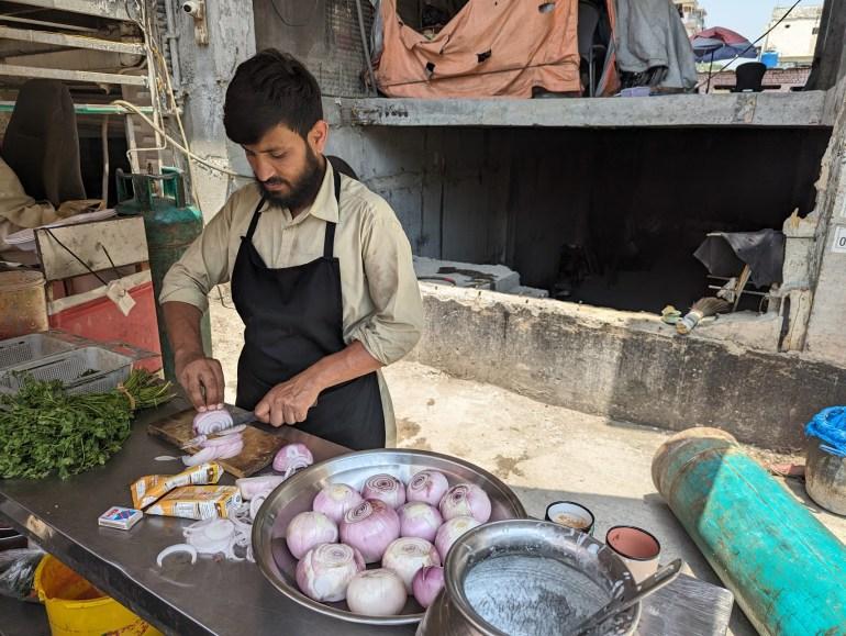 Chef Hamid Baloch prepares chicken curry at his cafe in Islamabad [Abid Hussain/Al Jazeera]
