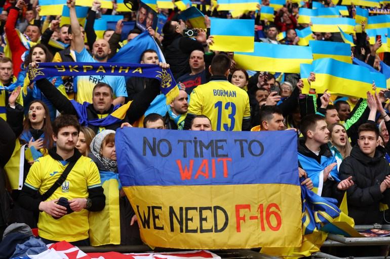 Ukrainian fan with a banner saying 'We need F-16' at Wembley Stadium, March 26, 2023.