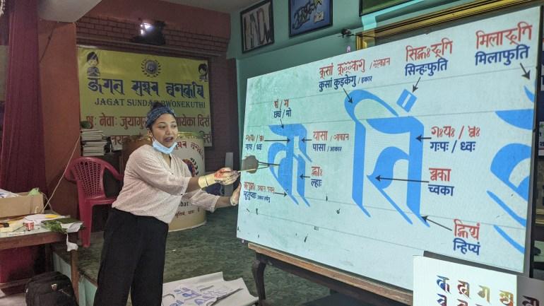 Sunita Dangol, a member of Callijatra, explains the Ranjana alphabet at a workshop