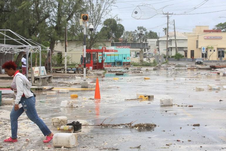 A woman walks through a debris filled street in the Hastings neighbourhood after Hurricane Beryl passed through Bridgetown, Barbados on July 1, 2024 [Nigel R Browne/Reuters]
