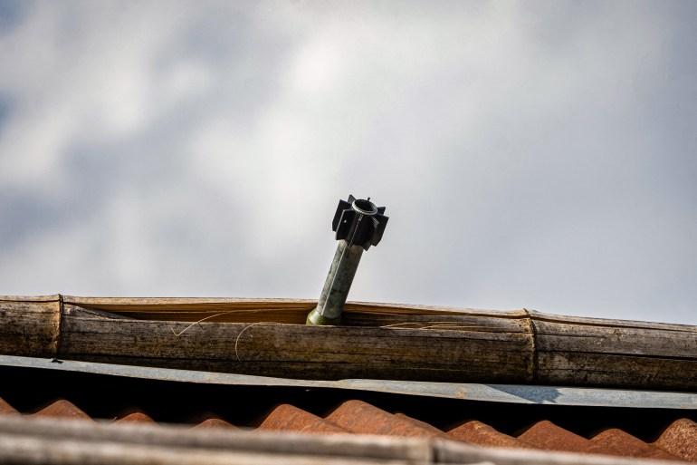 An unexploded projectile stuck on the roof of a house following fighting between Myanmar’s military and the Kachin Independence Army (KIA) in northern Shan State [File: AFP]