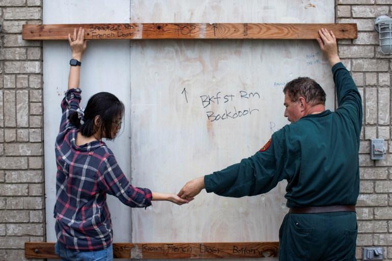 Shan Mei Martinez and Mario Martinez attach braces to secure their bay-facing door as residents prepare for the arrival of Hurricane Beryl in Port Lavaca, Texas, on July 7, 2024 [Kaylee Grenlee Beal/Reuters]